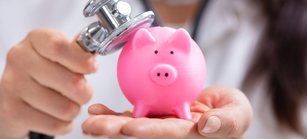 Close-up Of Doctor's Hand Examining Pink Piggybank With Stethoscope - Check up on your finances